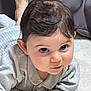 baby, infant, child, face, eyes, hair, ear, cheeks, hand, clothing, blanket, couch, tattoo, arm, portrait, closeup, indoor, gaze, curious_expression, floor