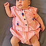 adorable, baby, casual, child, chubby_cheeks, comfortable, curious_eyes, cute, gray_bed_sheet, ice_cream_pattern, indoors, infant, lying_down, pink_clothing, portrait, relaxed, small_feet, small_hands, smiling, soft_skin