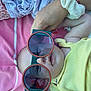 Alba participe au concours pour gagner de l'argent avec cette photo : baby, blanket, casual, child, cute, eyewear, fabric, face, glasses, hand, indoor, infant, person, pink_blanket, playful, resting, scrunchie, soft_texture, sunglasses, yellow_clothing