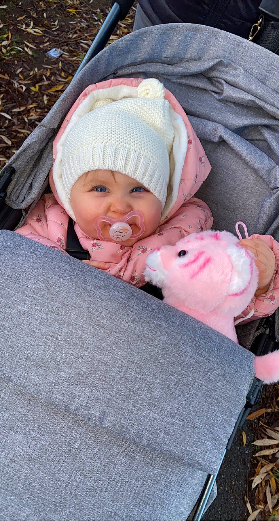 Luna participe au concours pour gagner de l'argent avec cette photo : baby, baby_products, baby_toddler_clothing, beanie, cap, cheek, child, comfort, face, grass, headwear, knit_cap, linens, lip, person, pink, sitting, skin, toddler, tree