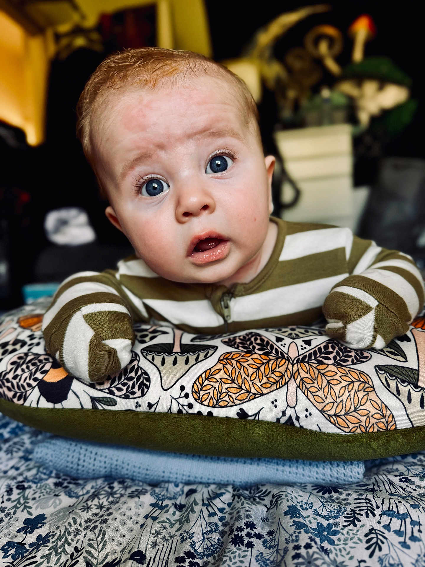Logan joined the competition — help win amazing prizes! baby, infant, face, wide_eyes, striped_clothing, pillow, patterned_fabric, mittens, expression, curious, indoor, close_up, portrait, child, person, soft_lighting, couch, blanket, cute, home