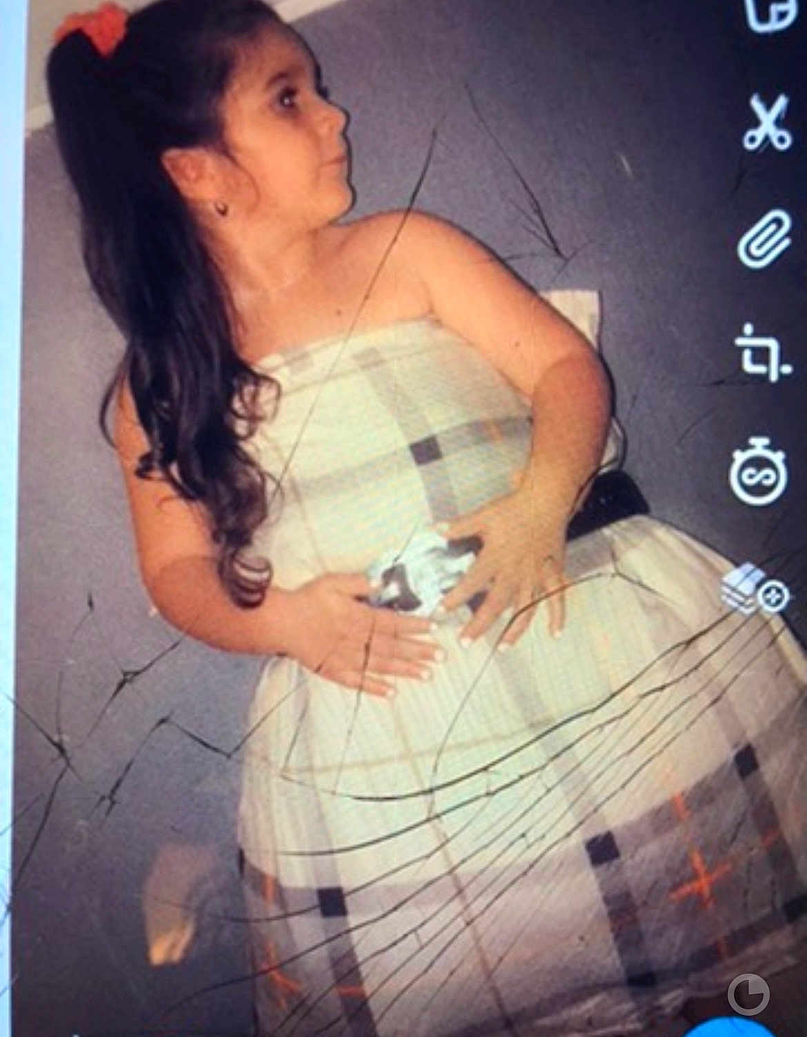Liana participe au concours pour gagner de l'argent avec cette photo : child, girl, dress, plaid_dress, long_hair, ponytail, portrait, indoor, wall, earring, hands, looking_right, standing, cracked_screen, screenshot, app_icons, skirt, pose, party, young