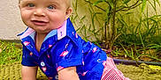 Jaxon Dean is registered to the contest to win money with this photo: baby, child, smiling, crawling, blue_shirt, pink_shorts, socks, green_blanket, grass, plants, outdoor, cute, portrait, happy, person, infant, nature, summer, bright, playful