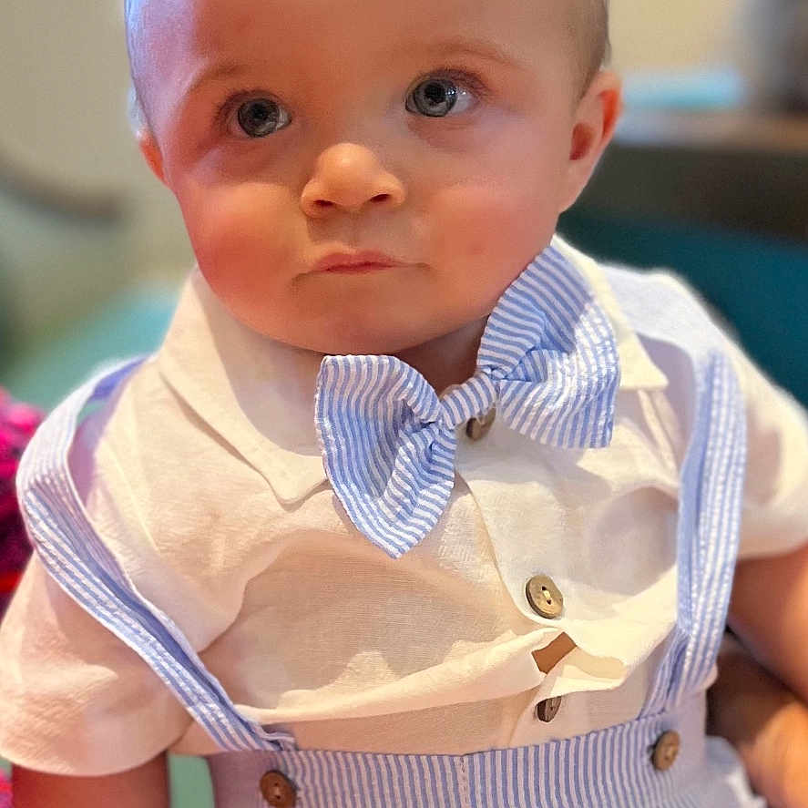 Jaxon Dean is registered to the contest to win money with this photo: baby, blue_eyes, bow_tie, child, closeup, clothing, cute, expression, face, fashion, hand, indoor, mohawk, person, portrait, seated, shirt, skin, suspenders, toddler