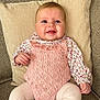 baby, child, couch, cozy, cushion, cute, face, floral_shirt, furniture, head, indoor, infant, knitted_clothing, legs, pink_outfit, portrait, seated, small_hands, smiling, texture