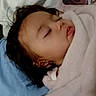 Selena is registered to the contest to win money with this photo: baby, sleeping, blanket, face, person, bed, pillow, video_call, glasses, indoor, portrait, child, rest, cozy, blanket_wrap, head, closeup, communication, technology, calm