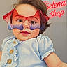 Selena joined the competition — help win amazing prizes! baby, child, glasses, red_glasses, purple_glasses, blue_shirt, ruffles, buttons, smiling, portrait, indoors, neon_sign, shop_sign, fashion, cute, person, face, hair, young_child, apparel
