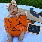 Catalina is registered to the contest to win money with this photo: baby, pumpkin, halloween, costume, headband, bow, blanket, grass, chalkboard, bat, decoration, outdoor, infant, holiday, cute, celebration, child, sitting, orange, festive