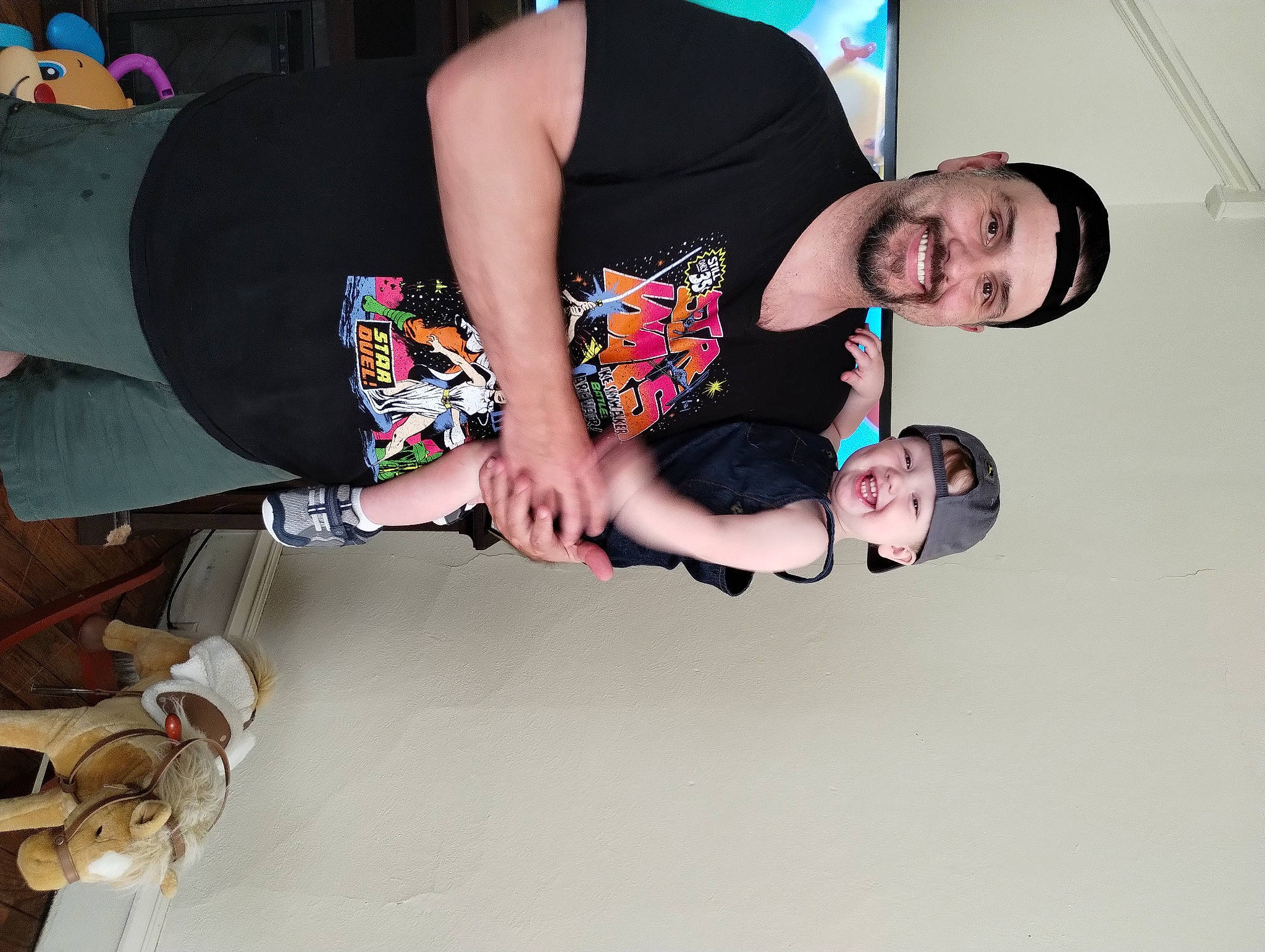 Manny Stanford is registered to the contest to win money with this photo: child, comfort, elbow, event, eyewear, flash_photography, fun, gesture, happy, headwear, human_body, human_leg, joy, knee, leg, mouth, person, room, smile, t_shirt