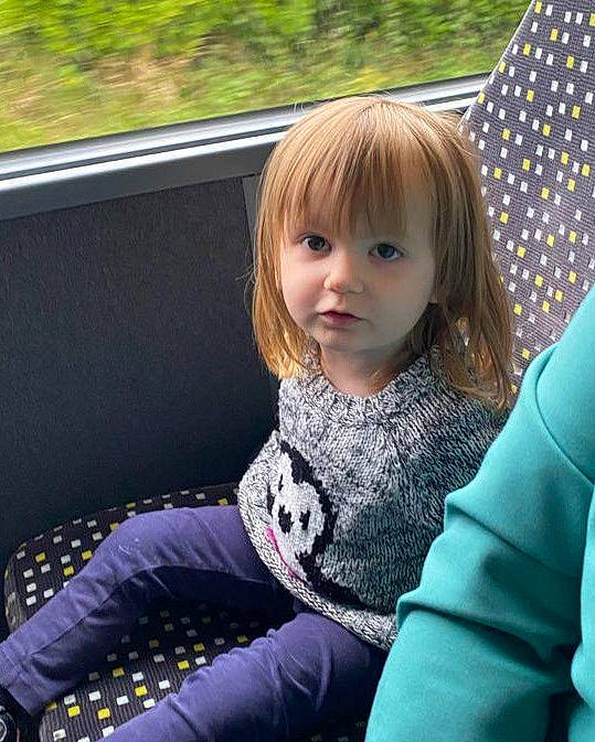 Enora participe au concours pour gagner de l'argent avec cette photo : arm, auto_part, baby_toddler_clothing, blond, child, comfort, cool, electric_blue, fun, grass, hairstyle, happy, human_body, leisure, person, sitting, sleeve, tints_and_shades, toddler, tree