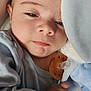 baby, infant, pacifier, plush_toy, blue_clothing, sleepy, close_up, soft_texture, hand, face, skin, newborn, cute, child, cozy, indoors, resting, blanket, young, comfort