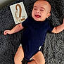 baby, infant, smiling, laughing, onesie, blanket, gray, card, giraffe, milestone, lying_down, happy, cute, child, skin, foot, hand, indoors, fabric, person