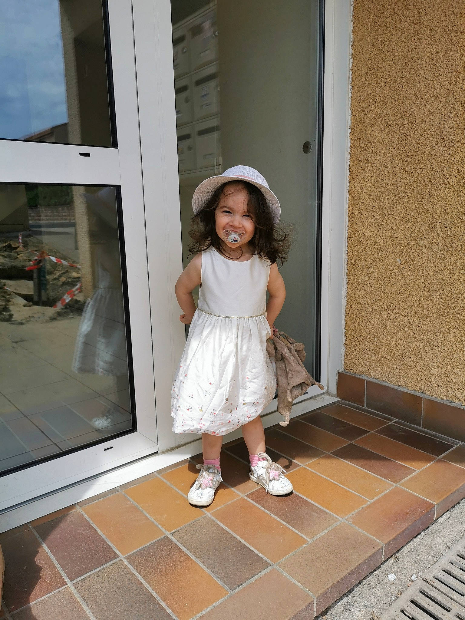 Lindsay a rejoint le concours — aidez-le/la à gagner de superbes lots ! child, composite_material, fashion_design, floor, flooring, fun, happy, hardwood, hat, human_leg, knee, person, room, sandal, shoe, sleeve, smile, sun_hat, thigh, toddler