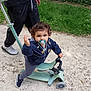 Diego a rejoint le concours — aidez-le/la à gagner de superbes lots ! adult, balance, casual, child, curly_hair, daylight, grass, greenery, hand, jacket, outdoor, pacifier, path, person, play, scooter, shoes, striped_pants, toddler, toy