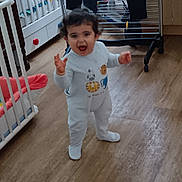 Diego a rejoint le concours — aidez-le/la à gagner de superbes lots ! baby, child, clothing, crib, curly_hair, drying_rack, furniture, happy, home, indoor, laundry, mouth_open, onesie, person, room, smiling, standing, toddler, toy, wooden_floor