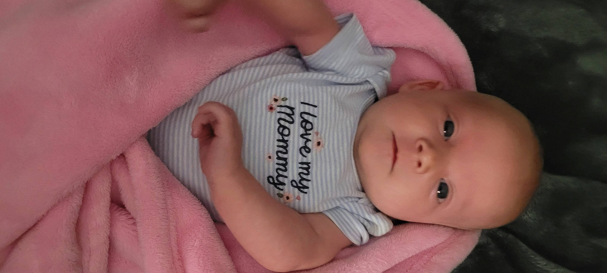 Harper is registered to the contest to win money with this photo: arm, baby, baby_toddler_clothing, cheek, chin, comfort, eye, eyebrow, eyelash, finger, gesture, hand, human_body, iris, lip, mouth, nose, person, pink, skin