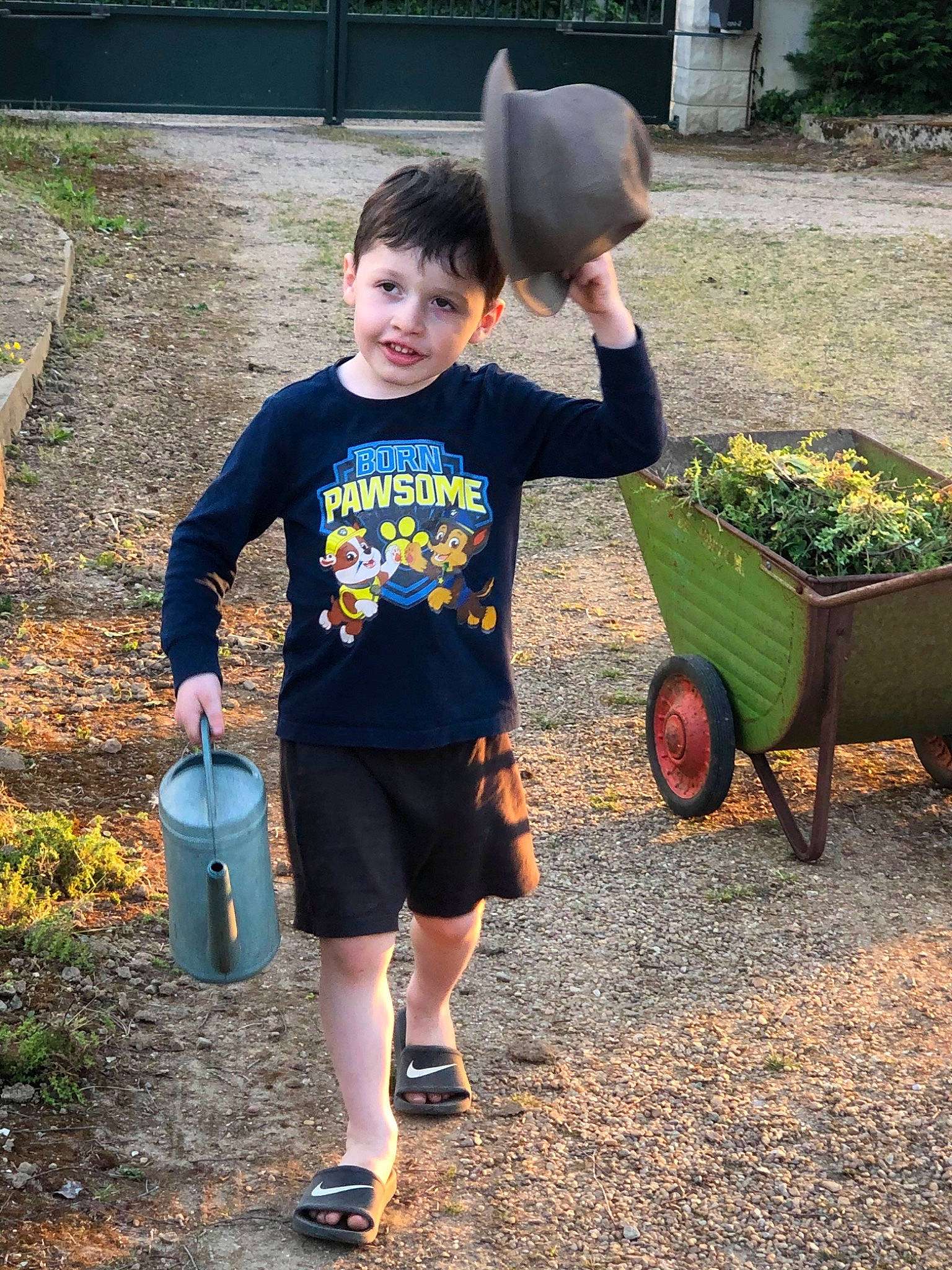 Timothy a rejoint le concours — aidez-le/la à gagner de superbes lots ! backyard, cart, child, fun, garden, gardening, grass, person, plant, shorts, smile, soil, t_shirt, toddler, tree, vacation, vehicle, wheelbarrow, yard