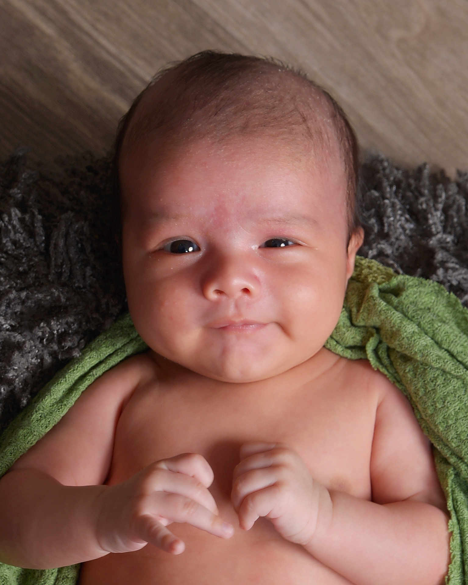 Julian is registered to the contest to win money with this photo: baby, infant, child, face, smile, hands, skin, towel, texture, blanket, portrait, cute, lying_down, indoors, young, newborn, expression, human, closeup, soft