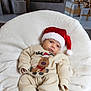 Angel is registered to the contest to win money with this photo: baby, blanket, celebration, child, christmas, christmas_decor, cozy, cute, festive, fireplace, holiday, indoors, infant, portrait, reindeer_sweater, santa_hat, sitting, smiling, warm, wrapped_gifts