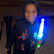 Christopher joined the competition — help win amazing prizes! child, smiling, hoodie, spiderman, light_stick, night, outdoor, flags, happy, person, shoe, pants, glowing, toy, celebration, festival, dark, colorful, portrait, fun