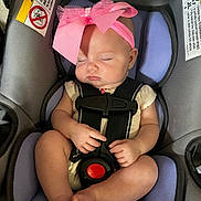 Paris is registered to the contest to win money with this photo: baby, infant, sleeping, car_seat, pink_bow, headband, child, straps, safety, cute, peaceful, skin, legs, hands, footwear_free, indoor, seat, transportation, resting, adorable