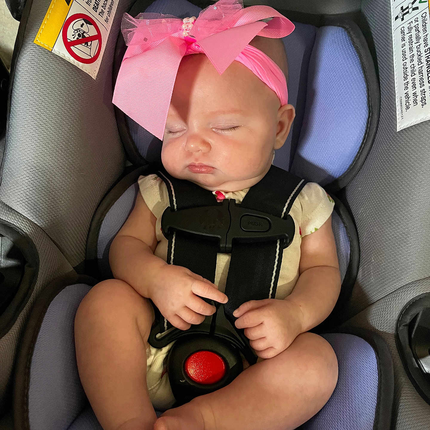 Paris is registered to the contest to win money with this photo: adorable, baby, car_seat, child, cute, footwear_free, hands, headband, indoor, infant, legs, peaceful, pink_bow, resting, safety, seat, skin, sleeping, straps, transportation