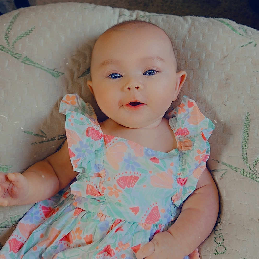 Morgan is registered to the contest to win money with this photo: baby, bodypart, clothing, couch, dress, face, fashion, finger, formalwear, furniture, gown, hand, happy, hat, head, person, photography, portrait, sitting, smile
