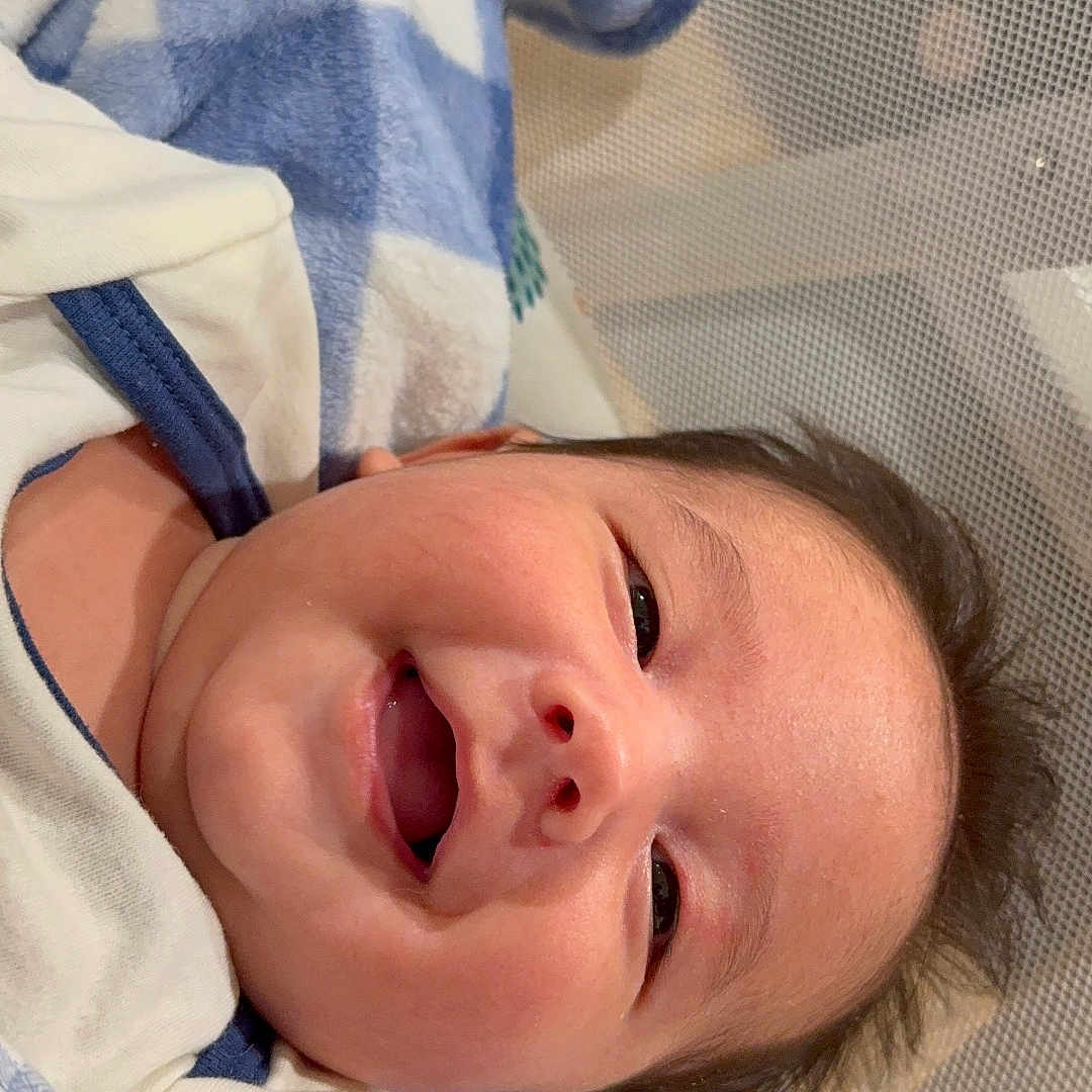 Thiago is registered to the contest to win money with this photo: baby, infant, child, portrait, face, wide_eyes, open_mouth, surprised, lying_down, blanket, blue_blanket, pacifier, baby_seat, mesh, indoors, cozy, close_up, head, eyes, clothing