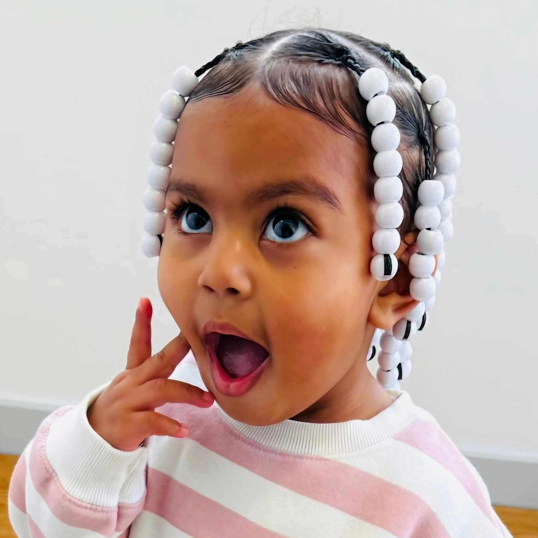 E'Layah joined the competition — help win amazing prizes! beads, braids, child, cute, expression, face, hair, happy, head, indoor, person, pink, portrait, skin, striped, surprised, sweater, toddler, white, young_child