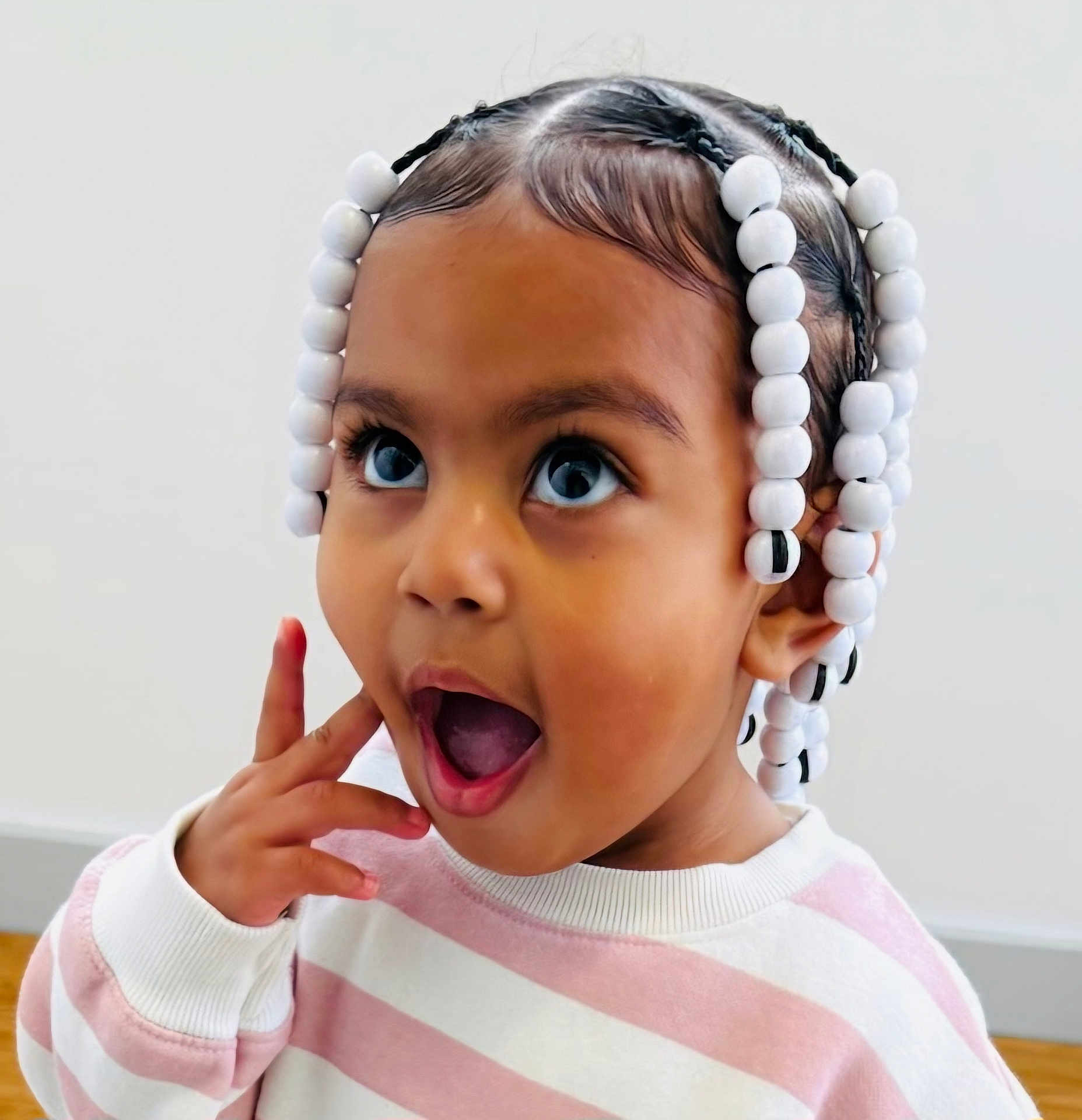 E'Layah joined the competition — help win amazing prizes! toddler, child, braids, beads, surprised, expression, face, portrait, sweater, pink, white, striped, indoor, cute, young_child, person, happy, skin, head, hair