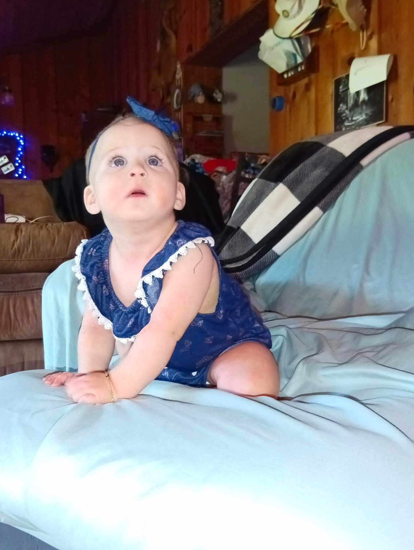 Skyleigh joined the competition — help win amazing prizes! baby, child, blue_dress, headband, crawling, bed, sheet, wood_paneling, room, indoor, furniture, curious, wide_eyes, bracelet, blanket, couch, light, soft, person, infant