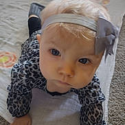 Abby is registered to the contest to win money with this photo: baby, child, headband, bow, crawling, blanket, leopard_print, blue_eyes, carpet, indoor, person, young_child, cute, clothing, infant, portrait, hand, face, expression, soft_lighting