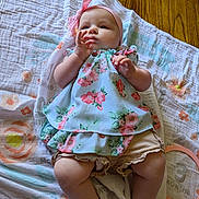 Abby joined the competition — help win amazing prizes! baby, infant, child, blanket, floor, wooden_floor, headband, bow, dress, floral_pattern, legs, hands, skin, cute, indoors, laying_down, person, apparel, soft_texture, natural_light