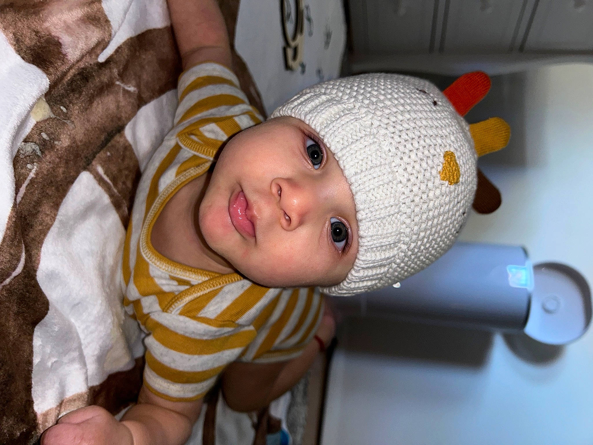 Karter is registered to the contest to win money with this photo: baby, baby_products, baby_toddler_clothing, cap, cheek, child, comfort, elbow, eye, fashion_accessory, fun, happy, hat, headwear, human_body, knit_cap, person, room, smile, thumb