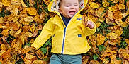 émile a rejoint le concours — aidez-le/la à gagner de superbes lots ! autumn_leaves, baby, baby_clothing, child, cute, fall, fall_colors, grass, green_pants, happy, infant, leaf, nature, outdoor, park, person, playful, seasonal, smiling, yellow_raincoat