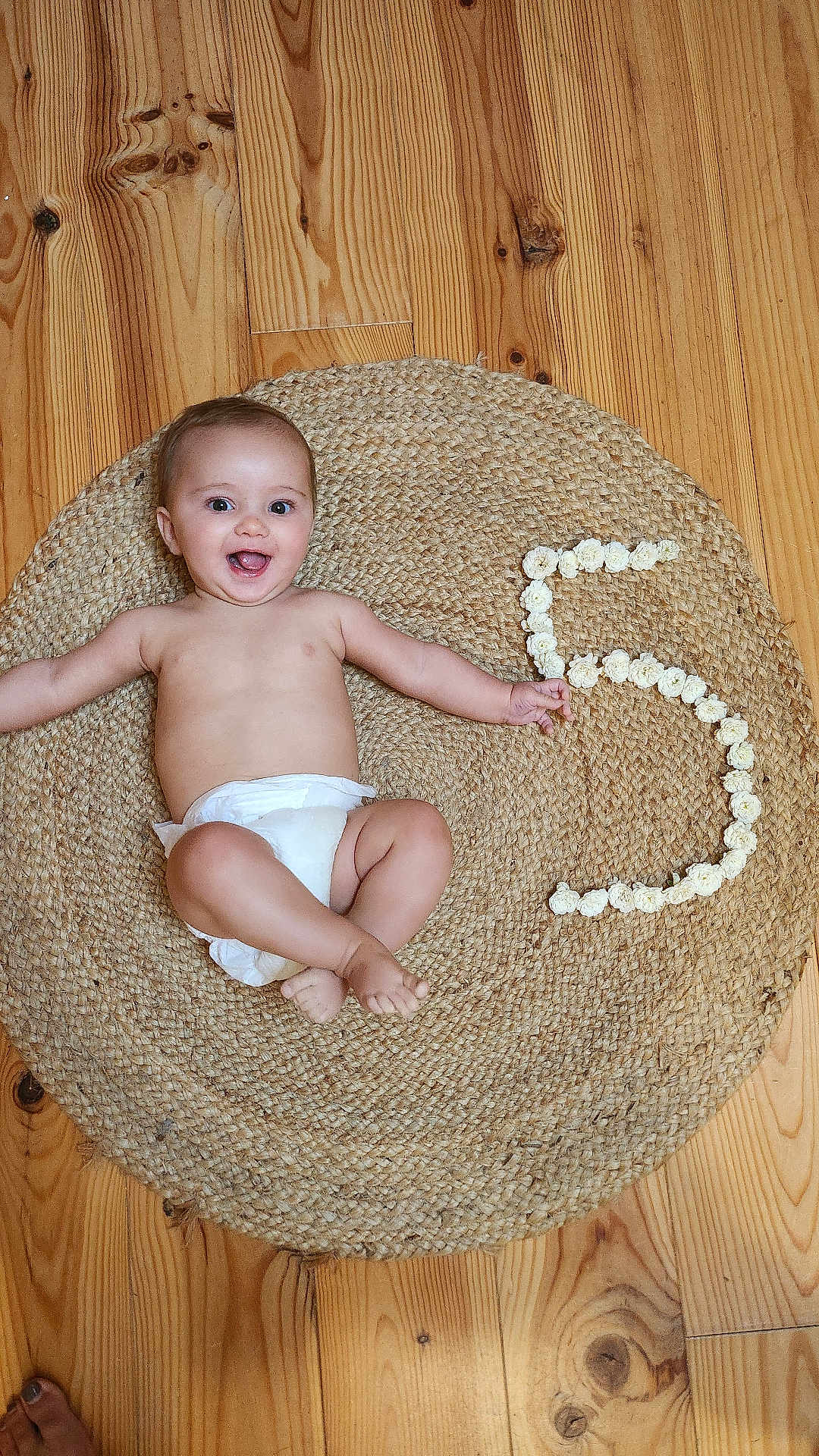 émile a rejoint le concours — aidez-le/la à gagner de superbes lots ! baby, diaper, smiling, happy, infant, floor, wooden_floor, rug, woven_rug, flowers, number_5, milestone, celebration, arms_outstretched, barefoot, indoor, child, cute, portrait, lying_down