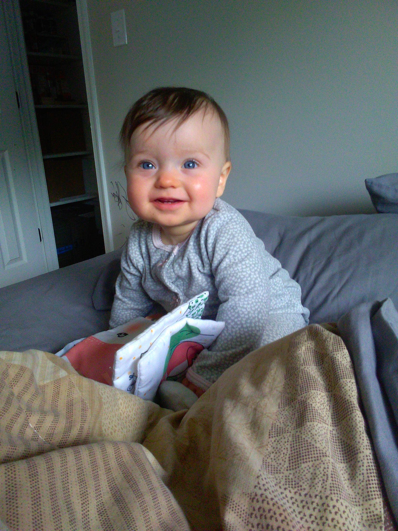 Josie is registered to the contest to win money with this photo: baby_toddler_clothing, child, comfort, couch, door, facial_expression, flash_photography, floor, flooring, happy, head, joy, knee, lap, linens, living_room, person, sitting, skin, sleeve