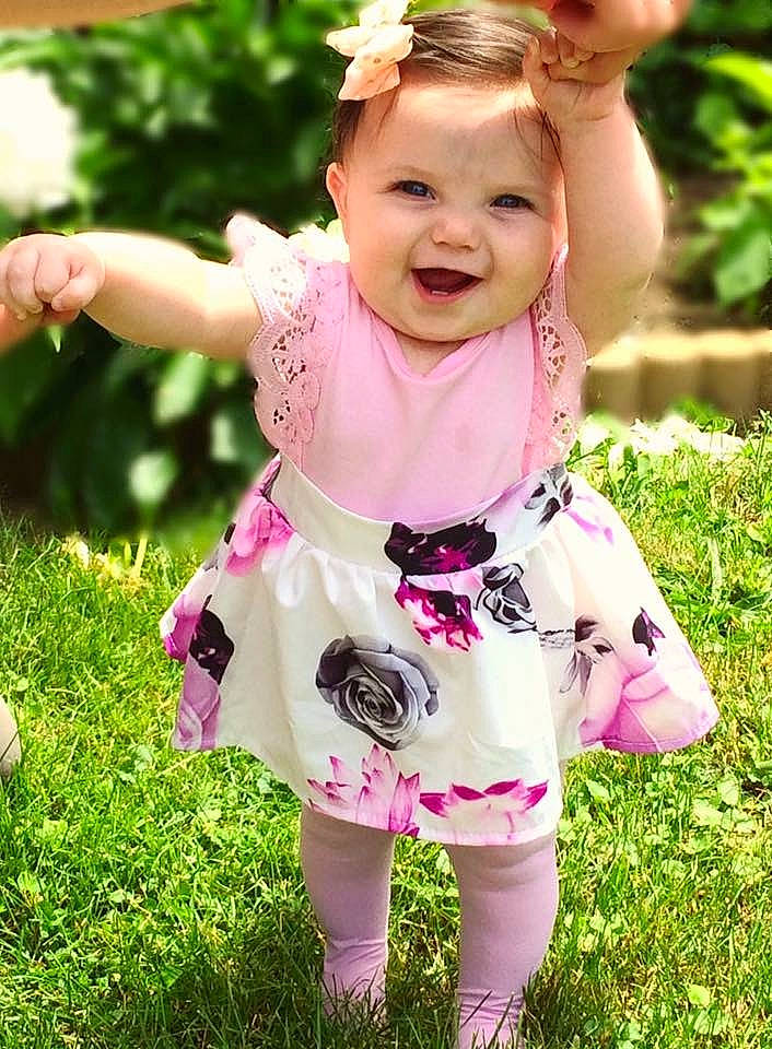 Emmarie is registered to the contest to win money with this photo: baby, baby_toddler_clothing, blond, child, child_model, clothing, dress, flower, grass, happy, joy, pattern, person, pink, plant, play, ruffle, smile, toddler