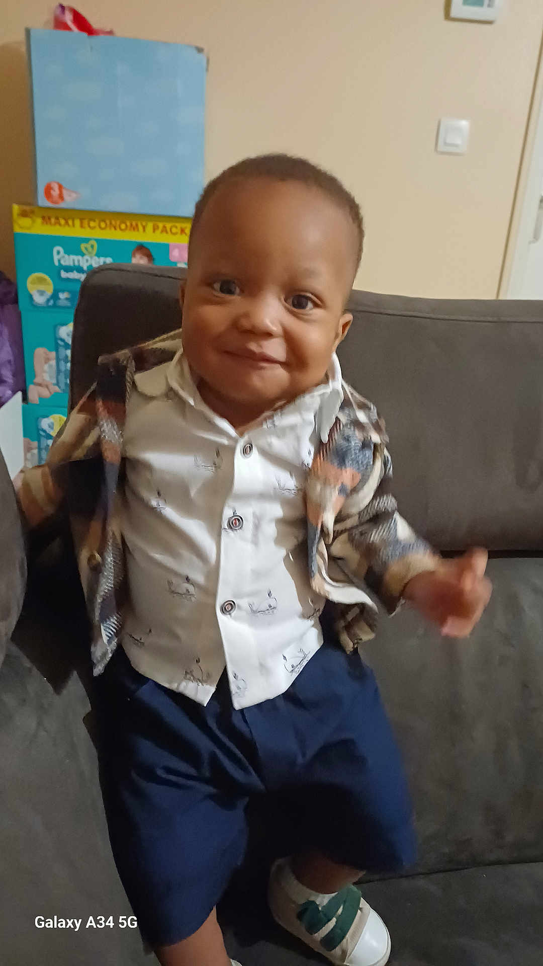 Tidi a rejoint le concours — aidez-le/la à gagner de superbes lots ! baby, child, clothing, couch, cute, face, furniture, happy, home, indoor, jacket, person, portrait, shirt, shoes, shorts, sitting, smile, toddler, young_child