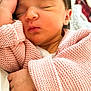 newborn, baby, sleeping, pink_sweater, knitted, hand, face, closed_eyes, blanket, soft_texture, cozy, infant, child, portrait, peaceful, cute, resting, warm_colors, indoors, closeup