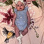 baby, infant, headband, bow, romper, socks, blanket, floral_pattern, bird_print, lying_down, cute, blue_stripes, daisies, curious_expression, indoors, soft_lighting, child, adorable, portrait, clothing