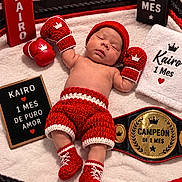 Kairo joined the competition — help win amazing prizes! baby, newborn, sleeping, portrait, boxing, boxing_gloves, championship_belt, knitted_clothing, red, white, crown, royal_theme, blanket, indoor, face, infant, costume, sports_theme, text_sign, photography