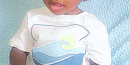 Kayden is registered to the contest to win money with this photo: baby, blue_blanket, casual_wear, child, clothing, curly_hair, cute, face, footwear, hands, happy, holding_object, indoors, portrait, sitting, soft_texture, toddler, white_tshirt, wooden_sign, young_child