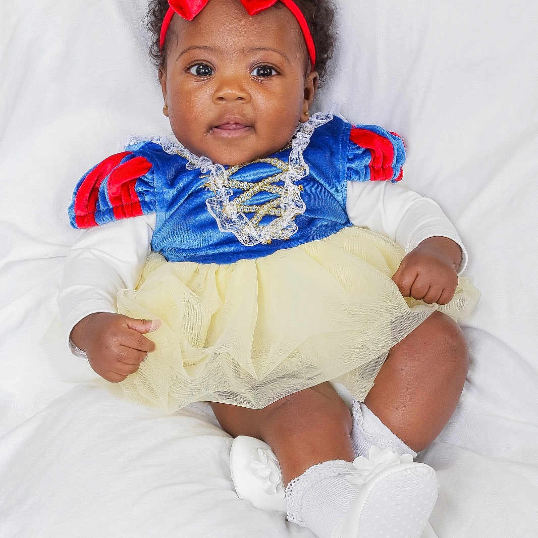 Yorrana a rejoint le concours — aidez-le/la à gagner de superbes lots ! baby, child, infant, dress, costume, headband, red_bow, white_background, sitting, cute, portrait, smiling, happy, fashion, footwear, socks, toddler, studio, clothing, face