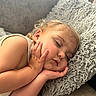 toddler, sleeping, child, face, hand, pillow, cozy, curly_hair, relaxation, indoor, soft_light, peaceful, couch, skin, rest, nap, young_child, portrait, comfort, furniture