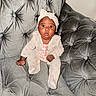 baby, infant, child, portrait, sitting, sofa, couch, tufted_furniture, gray, headband, bow, pink, onesie, baby_clothing, wide_eyed, looking_at_camera, indoor, home, photography, adorable
