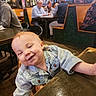 toddler, child, smile, denim_jacket, table, restaurant, indoor, people, seated, happy, face, cute, wood, casual_clothing, baby, high_chair, background, group, social, light