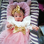 Chloe a rejoint le concours — aidez-le/la à gagner de superbes lots ! baby, infant, tutu, pink, gold_bow, headband, striped, cushion, seat, clothing, cute, wide_eyes, portrait, indoors, child, toddler, fabric, soft, bracelet, expression