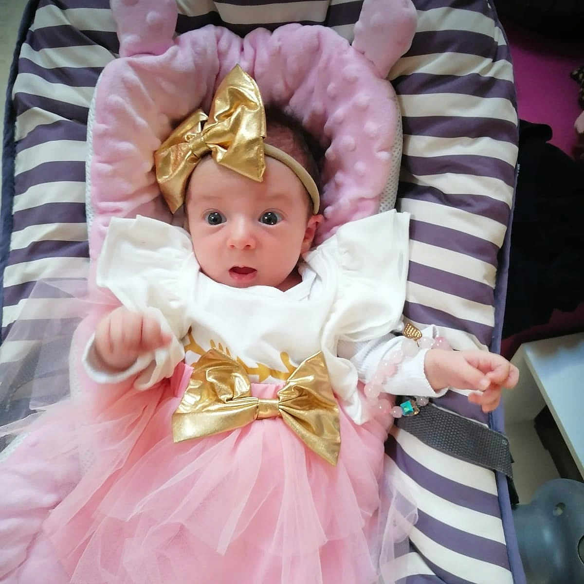 Chloe a rejoint le concours — aidez-le/la à gagner de superbes lots ! baby, bracelet, child, clothing, cushion, cute, expression, fabric, gold_bow, headband, indoors, infant, pink, portrait, seat, soft, striped, toddler, tutu, wide_eyes