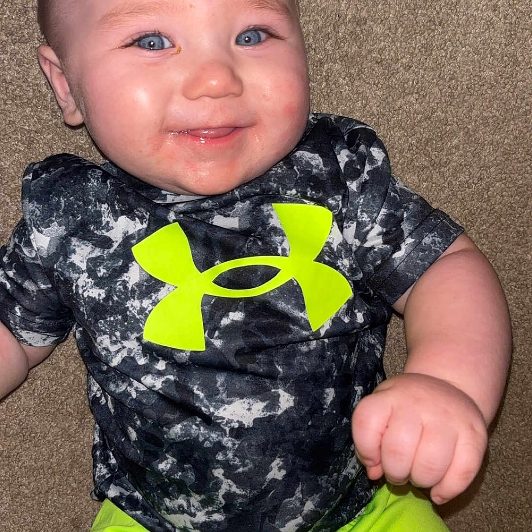 Dutton is registered to the contest to win money with this photo: baby, bodypart, clothing, coat, face, happy, head, homedecor, jacket, laughing, mouth, pants, person, photography, portrait, shirt, shorts, smile, t_shirt, teeth